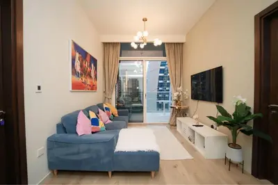 a living room with a blue couch and a tv at Luxury 2BR in Business Bay Close to Dubai Mall in Dubai