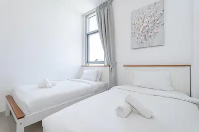 two beds in a white room with a window at StayShort - Cozy 2 Bedroom Retreat in Dubai South Close to Expo 2020 in Dubai Marina