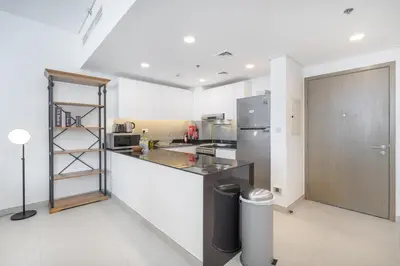 a kitchen with a counter top and a refrigerator at StayShort - Cozy 2 Bedroom Retreat in Dubai South Close to Expo 2020 in Dubai Marina