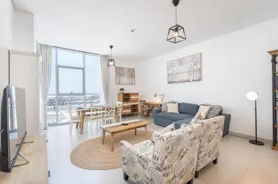 a living room with a couch and a table at StayShort - Cozy 2 Bedroom Retreat in Dubai South Close to Expo 2020 in Dubai Marina