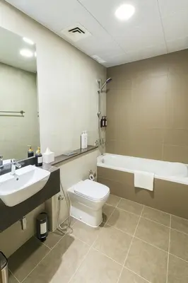 a bathroom with a sink and a toilet and a tub at Deluxe Apartments Near WTC and Sheikh Zayed in Dubai