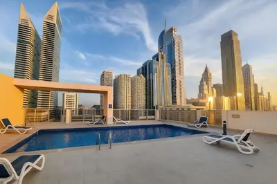 a swimming pool on top of a building with a city skyline at Deluxe Apartments Near WTC and Sheikh Zayed in Dubai