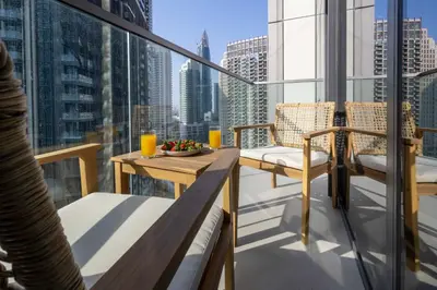 a balcony with a table and chairs on a building at Brand New 1BR - Burj View - Infinity Pool - Dubai Mall in Dubai