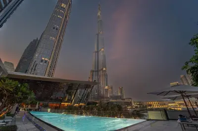 a swimming pool with a view of a city at night at Brand New 1BR - Burj View - Infinity Pool - Dubai Mall in Dubai