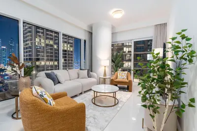 a living room with a couch and chairs and windows at Beachfront Luxury 1BR with Private Beach, Marina & Sea Views in Dubai