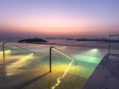 a pool of water with lights on top of a building at Beachfront Luxury 1BR with Private Beach, Marina & Sea Views in Dubai