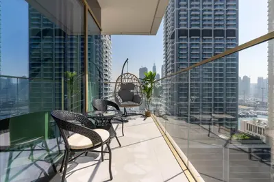 a balcony with chairs and tables on a building at Beachfront Luxury 1BR with Private Beach, Marina & Sea Views in Dubai