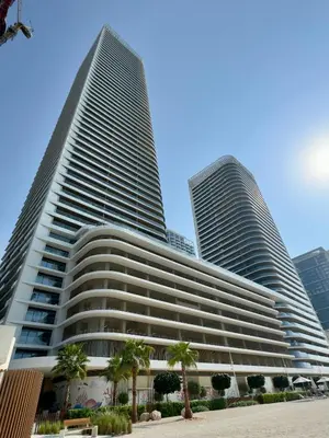 two tall buildings with palm trees in front of them at Beachfront Luxury 1BR with Private Beach, Marina & Sea Views in Dubai