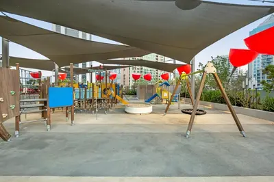 a park with a playground with swings at Chic Studio Steps to Dubai Mall with Infinity Pool in Dubai