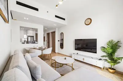 a living room with a couch and a tv at Stylish 1-Bedroom Apartment in JVC Dubai in Dubai