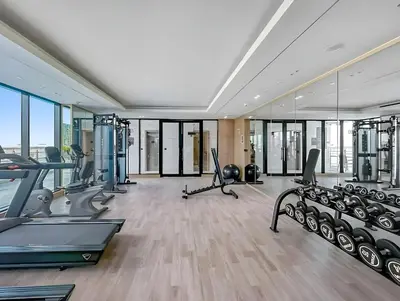 an apartment gym with treadmills and ellipticals at Stylish 1-Bedroom Apartment in JVC Dubai in Dubai