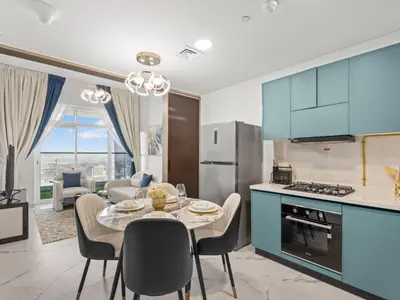 a kitchen and dining room with blue cabinets and a table and chairs at Opalz Serenity Designer- 1BDR Retreat-07 in Dubai