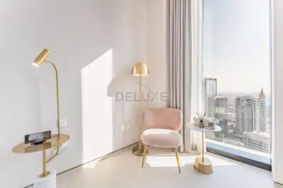 a living room with a pink chair and a large window at Balcony Facing the Marina with Partial Sea Views, Steps from the Beach and a Short Walk to Ain Dubai and Tram, The Address Residences, Jumeirah Beach Residence by Deluxe Holiday Homes in Dubai