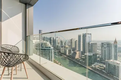 a balcony with a chair and a view of the city at Balcony Facing the Marina with Partial Sea Views, Steps from the Beach and a Short Walk to Ain Dubai and Tram, The Address Residences, Jumeirah Beach Residence by Deluxe Holiday Homes in Dubai