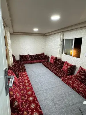 a living room with red couches in a room at dubai camp in ‘Ūd al Bayḑāʼ