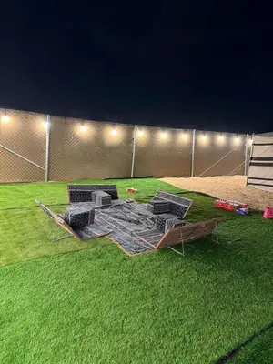 a group of chairs sitting on top of a grass field at dubai camp in ‘Ūd al Bayḑāʼ