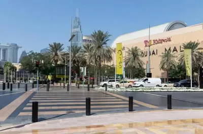 a city street with palm trees in front of a building at Vogue Downtown The Sterling by Omniyat, near Burj Khalifa and Dubai Mall, Studio Apartment with Balcony and Access to all Amenities in Dubai
