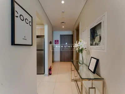 a room with a glass table with a vase of flowers at Sway Retreat 1BR Apartment with Burj Khalifa View in Dubai