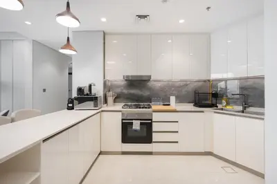 a kitchen with white cabinets and a stove at Comfortable 2BR Near Downtown by Czechin in Dubai
