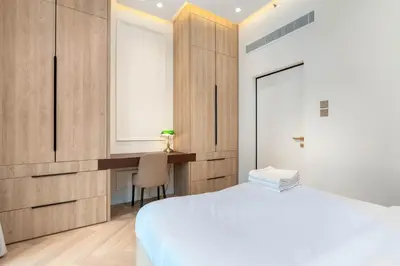 a bedroom with a white bed and a desk at Burj Khalifa View 5 Min walk to Dubai Mall in Dubai