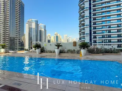a large swimming pool in a city with tall buildings at LUX The Dubai Marina Skyline Suite 2 in Dubai