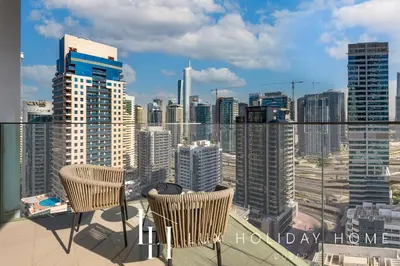 a balcony with two chairs and a city skyline at LUX The Dubai Marina Skyline Suite 2 in Dubai