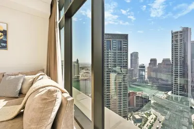 a room with a window with a view of the city at Curated High-Floor 1BR Water View Peninsula 1 in Dubai