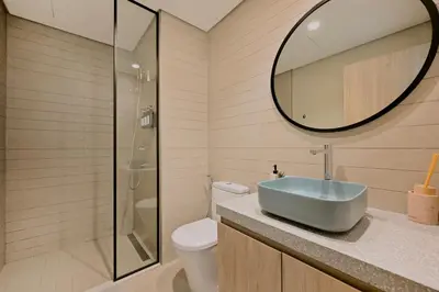 a bathroom with a sink and a toilet and a mirror at Curated High-Floor 1BR Water View Peninsula 1 in Dubai