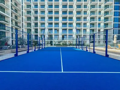 a tennis court in front of a building at WelHome - Urban Comfort Studio in JVC in Dubai