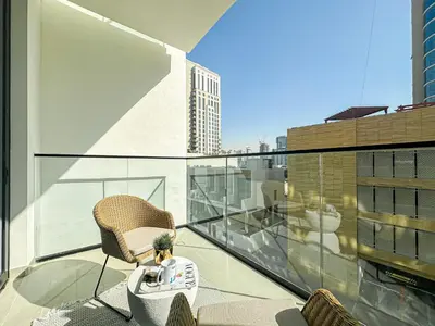 a balcony with a chair and a table on a building at WelHome - Urban Comfort Studio in JVC in Dubai