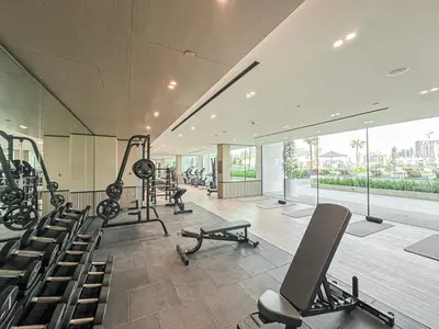 a gym with treadmills and machines in a building at WelHome - Stylish Dubai Studio in Prime JVC Location in Dubai