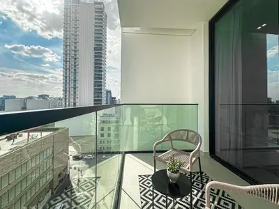 a balcony with a chair and a view of a city at WelHome - Stylish Dubai Studio in Prime JVC Location in Dubai