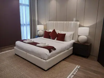 a bedroom with a large white bed with red pillows at Luxury 2BR Nobles Tower Business Bay by Czechin in Dubai