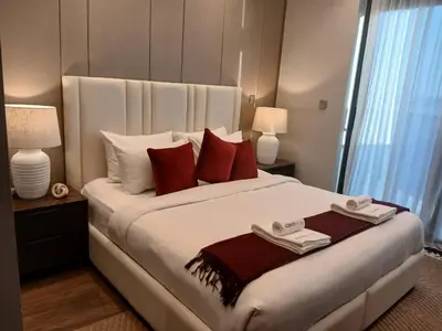 a bedroom with a large white bed with red pillows at Luxury 2BR Nobles Tower Business Bay by Czechin in Dubai