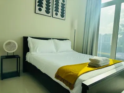 a bedroom with a bed with a yellow blanket on it at 1 BR luxury flat Damac hills2 in ‘Ūd al Bayḑāʼ