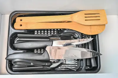 a container filled with knives and other kitchen utensils at 1 BR luxury flat Damac hills2 in ‘Ūd al Bayḑāʼ