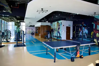 a gym with a ping pong table and equipment at Vogue Marina Gate near JBR Beach and Marina Mall, One Bedroom Apartment with Balcony and city skyline view, Access to all Amenities in Dubai