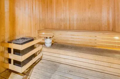 a wooden sauna with a bucket in it at Vogue Marina Gate near JBR Beach and Marina Mall, One Bedroom Apartment with Balcony and city skyline view, Access to all Amenities in Dubai