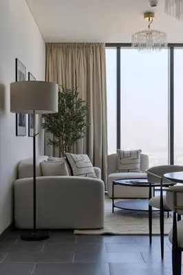 a living room with two couches and a table at Gentle brutalism apartments on Sobha Hartland 3BR in Dubai