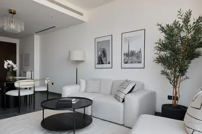 a living room with a white couch and a table at Gentle brutalism apartments on Sobha Hartland 3BR in Dubai