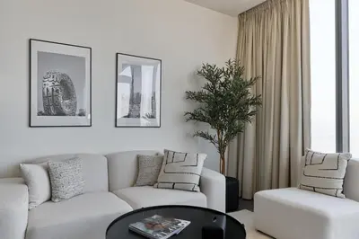 a living room with a couch and a table at Gentle brutalism apartments on Sobha Hartland 3BR in Dubai