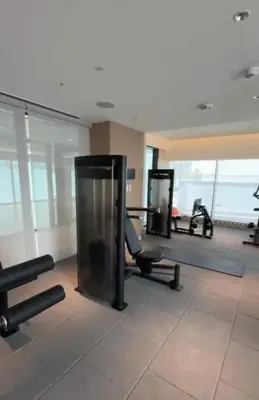 a gym with cardio equipment in a large room at Gentle brutalism apartments on Sobha Hartland 3BR in Dubai