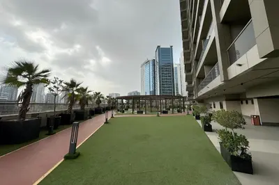 a courtyard in a building with a green lawn at Elite Downtown Studio with Balcony & Pool in Dubai