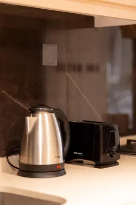 a tea kettle and toaster on a kitchen counter at Elite Downtown Studio with Balcony & Pool in Dubai