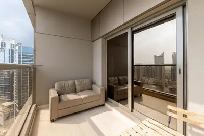 a living room with a couch and windows at Elite Downtown Studio with Balcony & Pool in Dubai