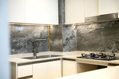 a kitchen with a sink and a stove at Well-Designed Modern 2 BHK Apartment Nobles Tower in Dubai