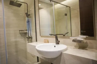 a bathroom with a white sink and a shower at Well-Designed Modern 2 BHK Apartment Nobles Tower in Dubai
