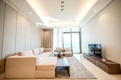 a living room with a couch and a tv at Well-Designed Modern 2 BHK Apartment Nobles Tower in Dubai