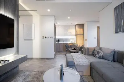 a living room with a couch and a table at High Rise Premium 2BR apt, PS5, Burj Khalifa view. in Dubai