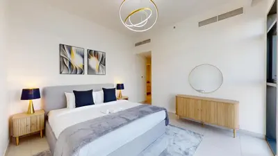 a bedroom with a large bed and a mirror at Vacationer l Vibrant 2 Bed l Dubai Hills Mall l Free Pool, Gym in Dubai